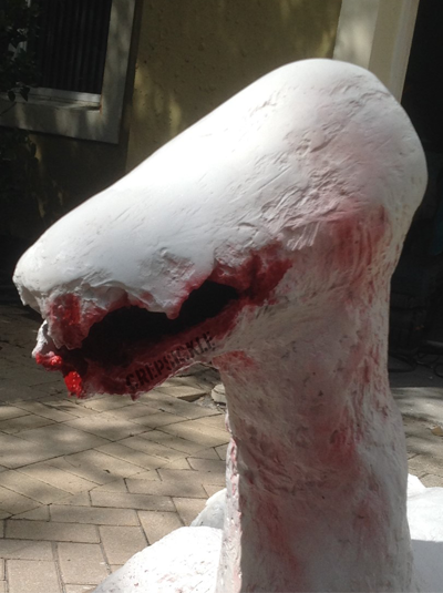 A large white paper mache lizard like creature
