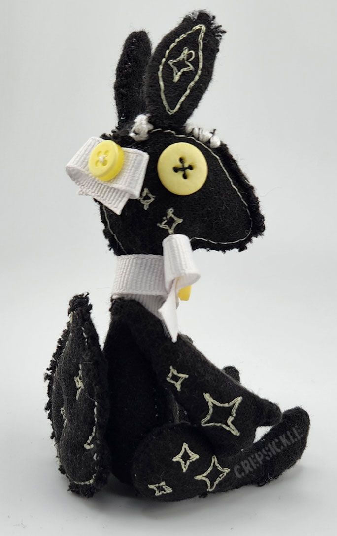A vintage styled black cotton creature with stars and a bow