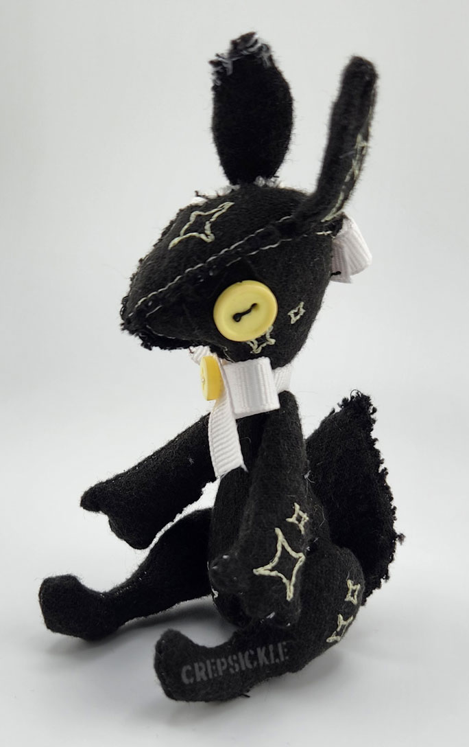 A vintage styled black cotton creature with stars and a bow